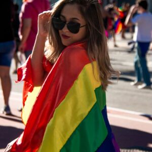 woman holding rainbow coloured flag