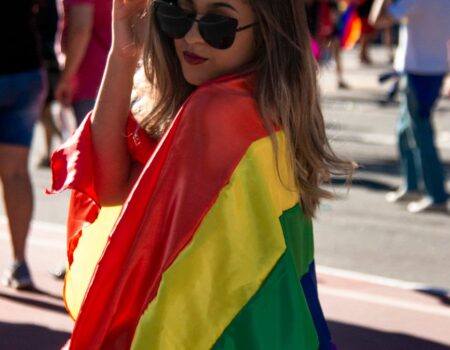 woman holding rainbow coloured flag